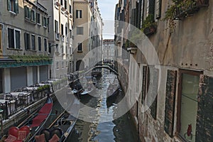 Traditional gondola ride in small canal at residential district of historical buildings and bridge, Venezia, Venice, Italy