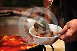 Traditional Goulash soup is cooking in the a cauldron