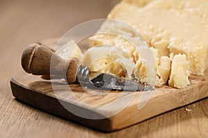 Traditional grana padano italian cheese on olive board photo