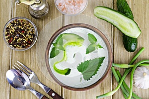 Traditional greek dip sauce or dressing tzatziki prepared with grated cucumber, yogurt, olive oil and fresh dill on wooden table