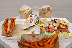 Traditional Greek fast food served on table in a cafe. Gyros sandwich, pita souvlaki, kalamaki and fries prepared for lunch in a