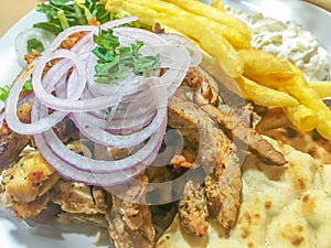 Traditional Greek gyros plate with fries and salad.