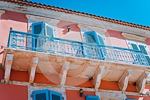 Traditional greek house facade with blue windows, shutters and balconies, Greece