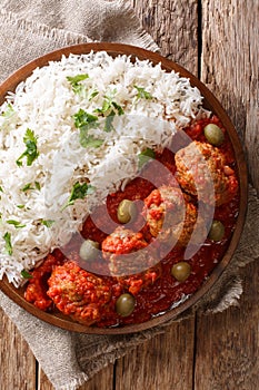 Traditional Greek meatballs in tomato sauce with rice close-up o photo