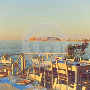 traditional greek outdoor restaurant on terrace at street village restaurant, Crete, Greece.