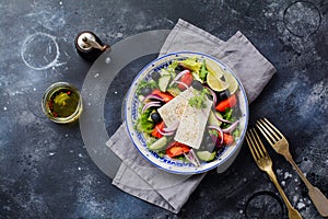 Traditional Greek Salad. Vegetarian dish with fresh lettuce, olives, peppers, cucumbers, onions and feta cheese.