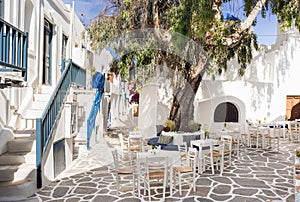 Traditional greek village Naoussa on Paros island, Greece. Beautiful street with cafe tables