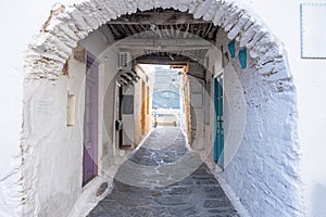 Traditional greek whitewashed buildings, cobblestone streets and stone structure arch. Ioulida village,Tzia, Kea island, Greece