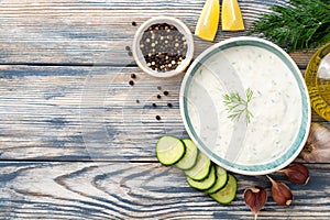 Traditional greek yogurt sauce tzatziki in bowl on wooden table