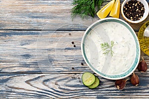 Traditional greek yogurt sauce tzatziki in bowl on wooden table