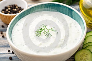 Traditional greek yogurt sauce tzatziki in bowl on wooden table