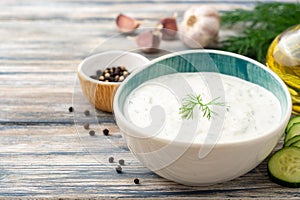 Traditional greek yogurt sauce tzatziki in bowl on wooden table