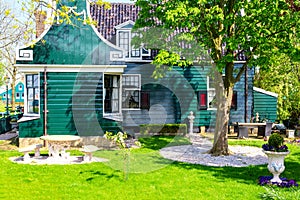 Traditional green dutch house in the Zaanse Schans village with green meadow. Typical Netherlands image. Famous tourist attraction