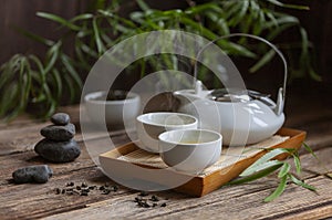 Traditional green tea ceremony set - white teapot and cups with stones piramide, house for the soul, on the tray