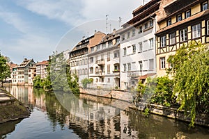 Traditional Half-Timbered Houses Along a Calm Canal in Strasbourg, France on a Sunny Day