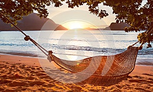 Traditional hammock in the shade at sunset on a calm tropical beach