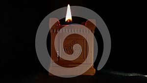 A traditional hand-made oil lamp is lit with the Om symbol used in Deepavali, Maha Shivaratri and many other religious festivals.