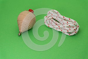 Traditional handmade wooden toy with metal tip and cord to launch the white and red spinning top.