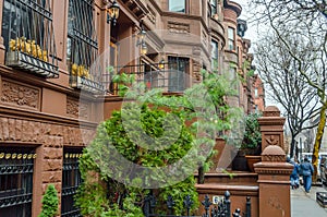 Traditional Harlem Neigborhood in New York City. Similar Style Brownstone Houses in a Row and People Walking on Pavement