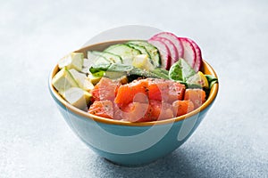 Traditional Hawaiian Poke salad with salmon, avocado rice and vegetables in a bowl