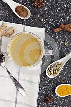 Traditional healthy masala tea - indian drink with spices star anise, cinnamon, turmeric on the cozy kitchen