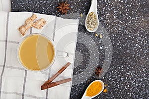 Traditional healthy masala tea - indian drink with spices turmeric, star anise, cardamom on the cozy kitchen with copy