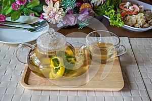 Traditional herbal tea with lemon, chamomile flowers and mint. Herbal tea with mint and chamomile. Peppermint tea in glass cup and