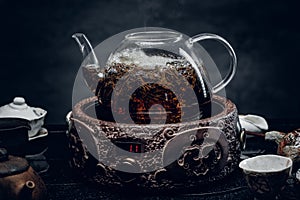 Traditional herbal tea in transparent glass teapot. Studio shot