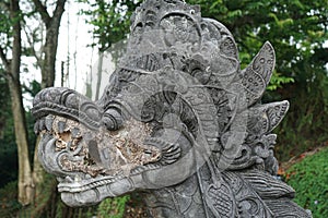 Traditional Hindu statue of dragon`s head in the garden in Bali photo