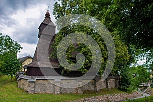 Traditional historical wooden church with brick wall fence of St. Francis of Assisi in Hervartov