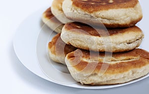 Traditional homemade fried patties or pies made of yeast dough in a rusticstyle on white plate