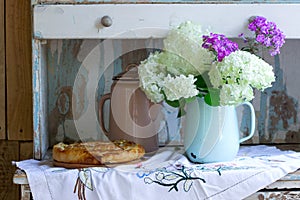 Traditional homemade Romanian and Moldovan pies - Placinta and a bouquet of flowers. Rustic style