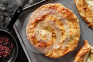 Traditional homemade Romanian and Moldovan round bread, served on a plate, dark background. Bakery products