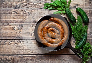 Traditional homemade spicy baked meat sausage with cucumber and herbs