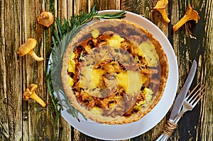 Traditional homemade swedish pie - quiche with chanterelle mushrooms, cheese and rosemary decorated with vintage kinife and fork