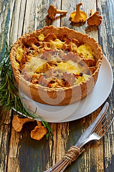 Traditional homemade swedish pie - quiche with chanterelle mushrooms, cheese and rosemary decorated with vintage knife and fork