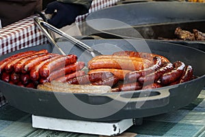Prague, Czech Republic 2019:Traditional hot dog preparation on coal fire on the street during the Christmas market