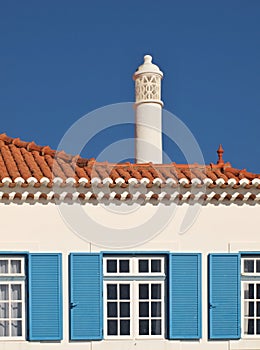 Traditional house facade in blue white with typical chimney