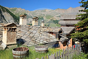 Traditional houses roofs and chimneys, with a mountain range in the background, Saint Veran