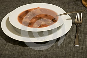 Traditional hungarian cherry soup with apple and carrot in a bowl on a table