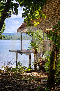 Traditional hut overlooking calm lagoon waters in the Solomon Islands.