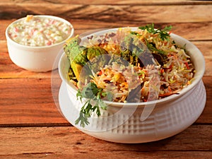 Traditional Hyderabadi Chicken dum Biryani made of Basmati rice cooked with masala spices, served with Onion raita, selective