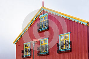 Traditional Icelandic red ironclad building with colorful windows and roof, Reykjavik,