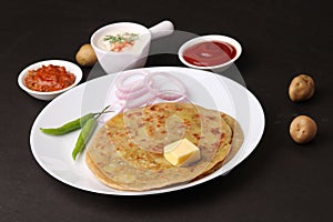 Traditional Indian food Aloo paratha or potato stuffed flat bread. served with pickle