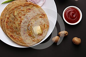 Traditional Indian food Aloo paratha or potato stuffed flat bread. served with pickle