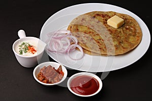 Traditional Indian food Aloo paratha or potato stuffed flat bread. served with pickle