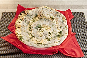 Traditional indian garlic naan made in a pakistani restaurant in europe with mucho parsley and sesame seeds