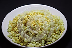 Traditional Indian Gujarati snack sev mamra  in the decorative dish on black background