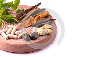 Traditional Indian medicine concept. Cinnamon, dried ginger, black cardamom, javitri, long pepper, and ayurvedic capsules with