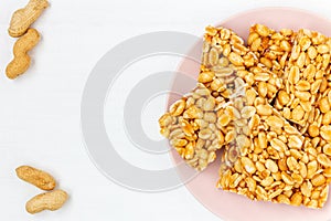 Traditional indian peanut chikki on plate on white background  top view